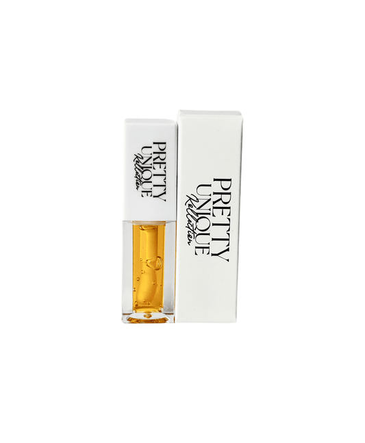 Mango Xclusive Lip Plumper Oil in clear tube with white cap, shown beside matching white retail box. Glossy, hydrating formula for fuller lips.